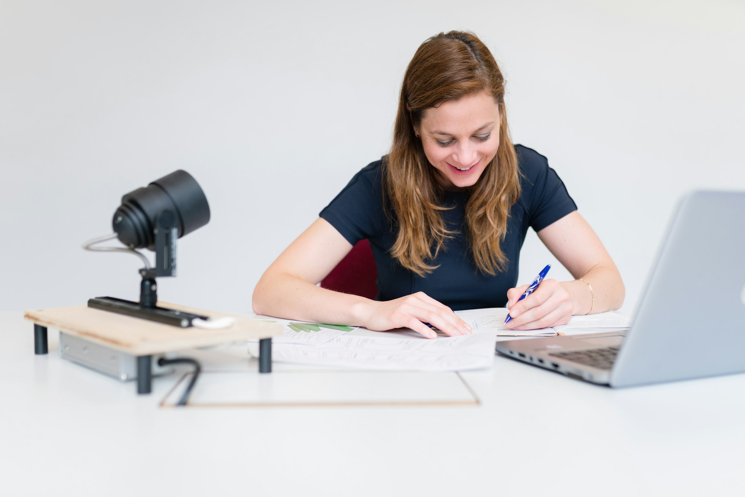 A student writing notes at a desk while preparing for a language test